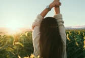 Donna di spalle in un campo di girasoli