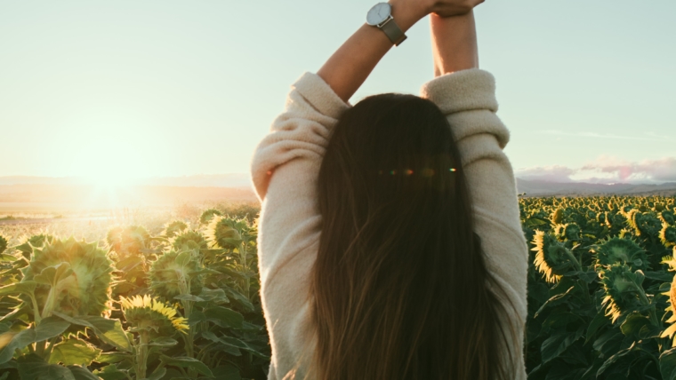 Donna di spalle in un campo di girasoli