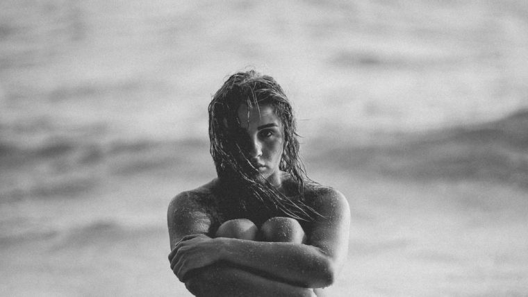 donna seduta sulla riva in bianco e nero